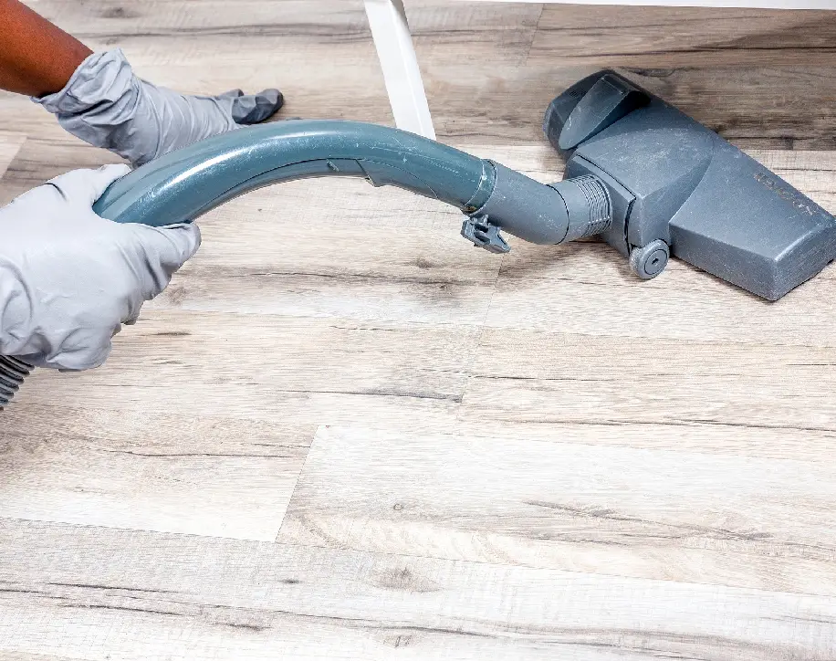 A person is holding an industrial hose on the floor.